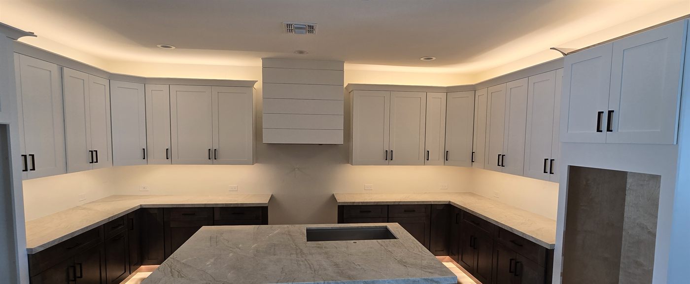 Finished kitchen with quartzite waterfall island and two-tone cabinets
